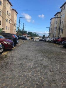 brukowana ulica z zaparkowanymi samochodami na parkingu w obiekcie Apartamento - Salvador BA w mieście Salvador