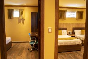 a bedroom with a bed and a desk and a chair at FORTICH APART HOTEL in Guayaquil +34 photos