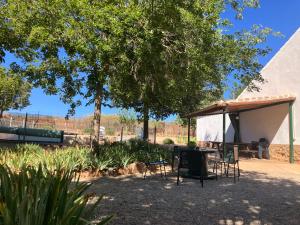 a patio with a table and chairs under a pavilion at La Huerta el Bao in Alhambra