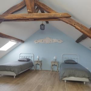 two beds in a attic room with wooden beams at Spacieux duplex en plein centre-ville de Fontainebleau in Fontainebleau