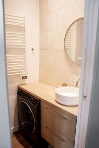a bathroom with a sink and a washing machine at Apartamento panorámico in Charenton-le-Pont +22 photos