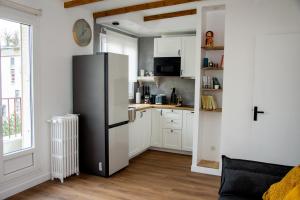 a kitchen with a black refrigerator in a room at Apartamento panorámico in Charenton-le-Pont