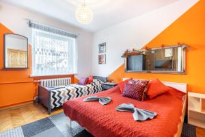 a bedroom with orange walls and a bed and a couch at Pokoje Goscinne Oliwia & Laura I in Rumia