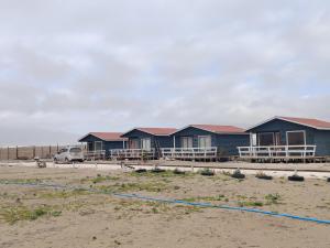 a row of blue houses on the beach at Cabañas el llano punta de choros in Choros Bajos