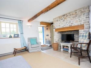 a living room with a stone fireplace and a tv at 3 Bed in Lulworth Cove DC023 in West Lulworth