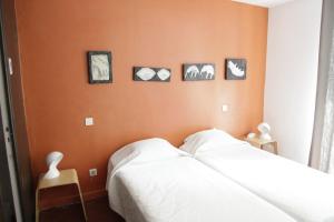 a bedroom with a bed with four pictures on the wall at Hotel Burrhus in Vaison-la-Romaine