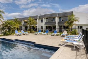 a resort with lounge chairs and a swimming pool at Avalon Motel Thames - Wenzel Motels in Thames