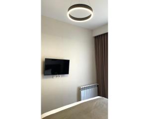 una camera da letto con una TV a schermo piatto sul muro di Crystal Loft Bakuriani - A406 a Bakuriani