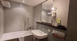 La salle de bains est pourvue d'un lavabo et d'une baignoire. dans l'établissement Hotel Burrhus, à Vaison-la-Romaine