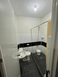 ein Badezimmer mit 2 WCs, einem Waschbecken und einem Spiegel in der Unterkunft The George Residence in Tarlac City