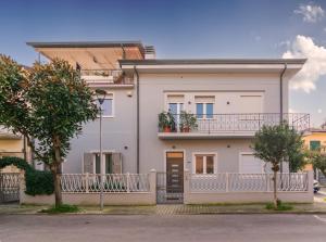 ein weißes Haus mit einem Balkon und Bäumen in der Unterkunft Casa vacanze da Antonio ristrutturata LUGLIO 2023 in Viareggio