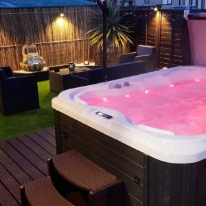 a bath tub filled with pink water in a room at Nualas Holiday Lodge York in Wilberfoss