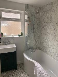 a bathroom with a shower and a tub and a sink at Sea view Cottage in Cleethorpes