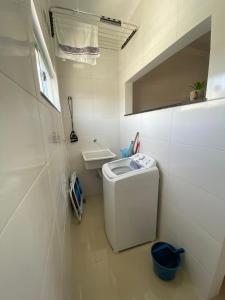ein kleines weißes Bad mit einer Waschmaschine in der Unterkunft Apartamento Vista Mar in Porto Seguro