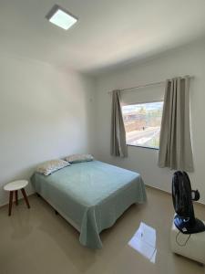 ein weißes Schlafzimmer mit einem Bett und einem Fenster in der Unterkunft Apartamento Vista Mar in Porto Seguro