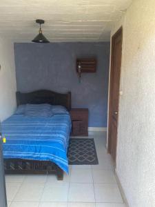 una camera con letto e parete blu di Berlin61 a San Cristóbal de Las Casas
