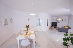 uma sala de estar branca com uma mesa e um sofá em Villa Cervus Dianae em Kallithea Rhodes