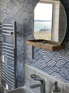 a bathroom with a mirror and a sink at Sea Biscuit Cottage, Scarborough in Scarborough