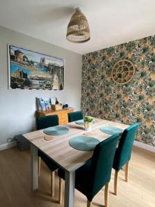 a dining room with a table and blue chairs at Sea Biscuit Cottage, Scarborough in Scarborough