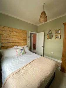 a bedroom with a large bed with a wooden headboard at Sea Biscuit Cottage, Scarborough in Scarborough