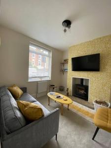 a living room with a couch and a fireplace at Sea Biscuit Cottage, Scarborough in Scarborough