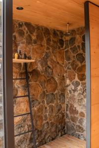 a room with a stone wall with a ladder at Hotel Cuatro Cuatros in Ensenada