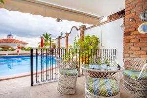 een patio met een tafel en stoelen naast een zwembad bij Playa Bonita in Puerto Vallarta
