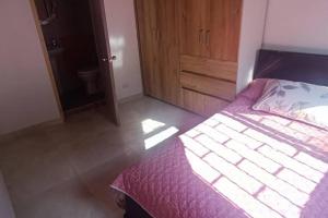 a bedroom with a bed and a wooden cabinet at Apartamento Amoblado en Laureles in Medellín