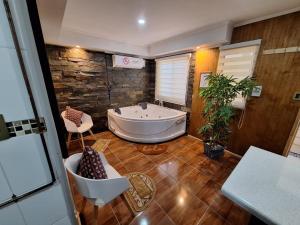 baño grande con bañera y planta en Cabañas Ases Loft Valdivia SIN ESTACIONAMIENTO, en Valdivia