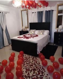 a bedroom with a bed with red balloons on the floor at Y Beautiful and comfortable in Moca