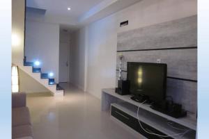 卡波布里奧的住宿－Apartamento Cobertura em Cabo Frio 3 suítes，一间带电视和楼梯的客厅