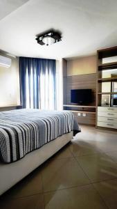 卡波布里奧的住宿－Apartamento Cobertura em Cabo Frio 3 suítes，一间卧室设有一张带电视和窗户的床。