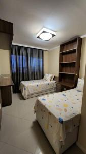 卡波布里奧的住宿－Apartamento Cobertura em Cabo Frio 3 suítes，酒店客房设有两张床和窗户。