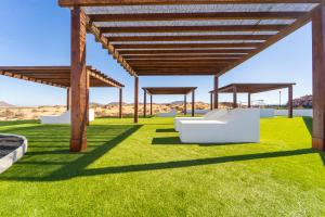 Villa Colibri Azul في لاجاريس: جناح مع عشب أخضر وهياكل خشبية