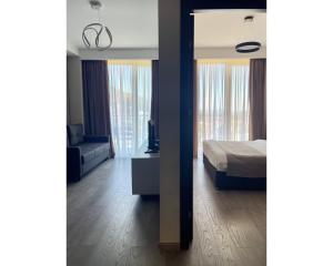 una camera da letto con un letto, un divano e finestre di Crystal Loft Bakuriani - A406 a Bakuriani