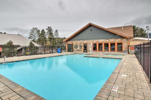 a large blue swimming pool in front of a house at Ski-InandSki-Out Cranmore Mountain Resort Condo! in Conway