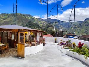 a restaurant with mountains in the background at Hostel Plantas y Blanco in Baños