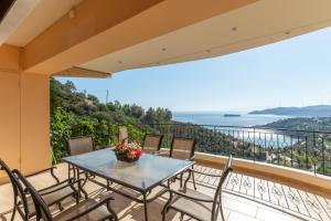 a table and chairs on a balcony with a view at Villa Lumière- Avantes in Agioi Apostoli