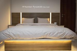 a bedroom with a large bed with a wooden frame at Narmer Pyramids View in Cairo