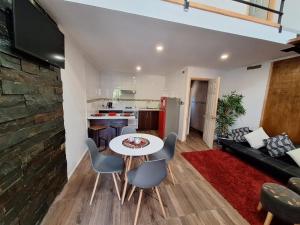 a kitchen and a living room with a table and chairs at Cabañas Ases Loft Valdivia SIN ESTACIONAMIENTO in Valdivia