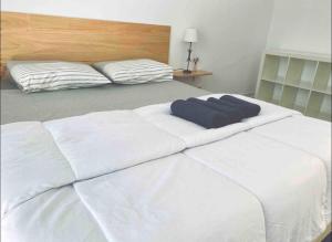 un letto bianco con due cuscini sopra di Self-Check in Sunny & Charming Apt a Coimbra