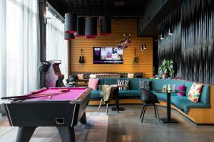 a billiard room with a pool table and a tv at Moxy Aberdeen Airport in Dyce