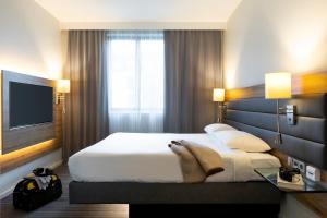 a hotel room with a bed and a television at Moxy Aberdeen Airport in Dyce
