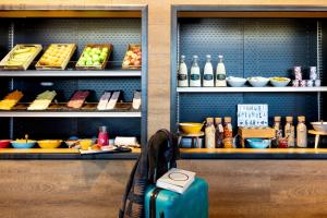 a suitcase sitting on a bench in front of a bakery at Moxy Aberdeen Airport in Dyce