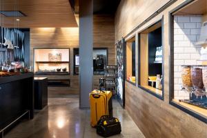 a yellow suitcase sitting on the floor in a restaurant at Moxy Aberdeen Airport in Dyce