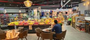 un hombre sentado en una mesa en una tienda de comestibles en Ocean view 8min from the beach Dubai Marina JBR " My Home ", en Dubái