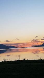 a large body of water with a sunset in the background at Fort William loft on shore front with amazing views in Caol