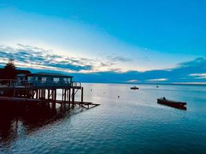 a dock with a house on it in the water at Hill Grove 2 Bedroom Apartment in Southend-on-Sea