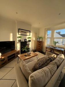 a living room with a couch and a television at Hill Grove 2 Bedroom Apartment in Leigh-on-Sea