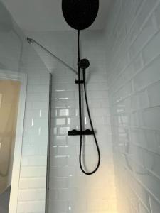 a shower with a hose hanging from a wall at Hill Grove 2 Bedroom Apartment in Southend-on-Sea
